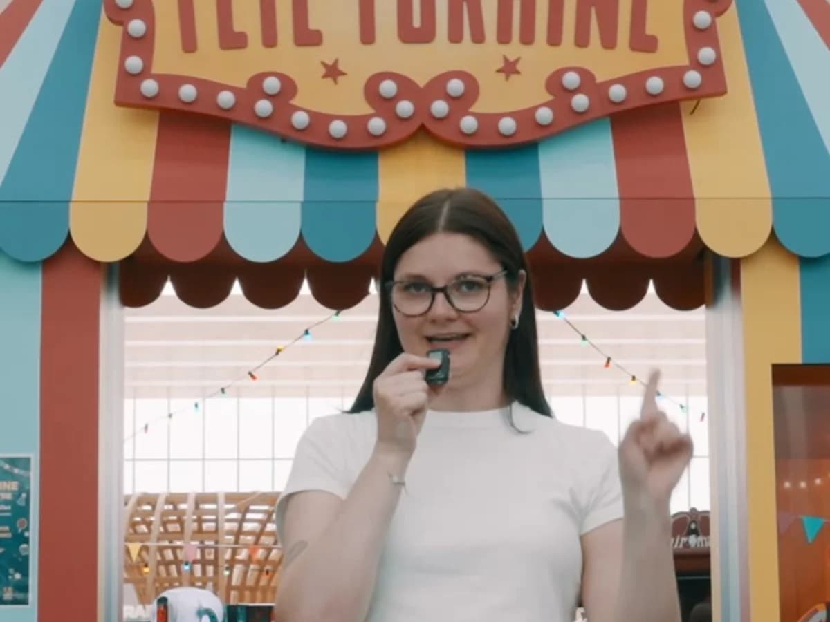 Une influenceuse au micro devant la fête foraine du festival